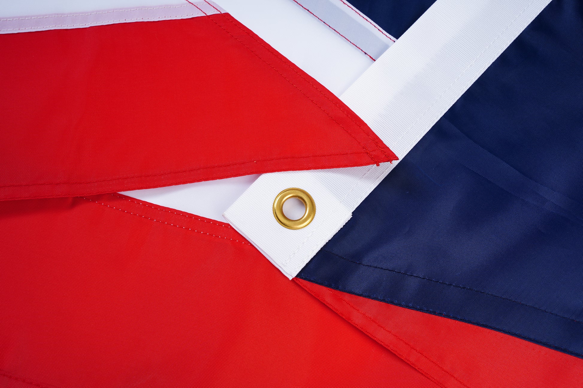 Close-up of the Ohio State Flag by Flag Stars Inc, showing overlapping red, white, and blue outdoor-ready fabric with a gold metal grommet—100% Made in USA.
