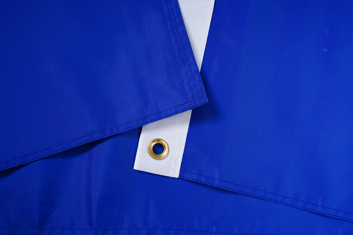 Close-up of the Oregon State Flag by Flag Stars Inc—blue and white synthetic fabric with a brass grommet, 100% Made in USA, ideal for outdoor use as tarps or banners.