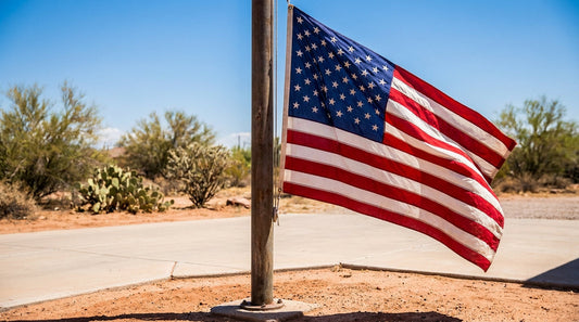 A fade-resistant American flag flying from a residential flagpole in bright Arizona desert sun with crisp red, white, and blue colors