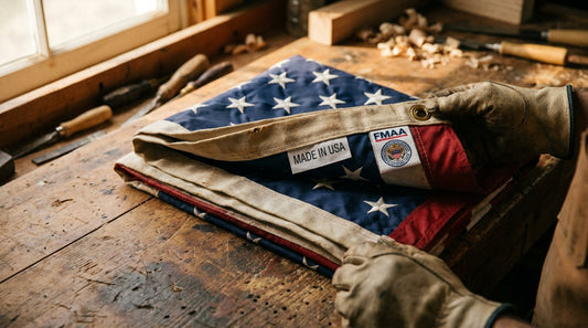 Sewn-in Made in USA label and FMAA certification seal on a nylon American flag header with brass grommets