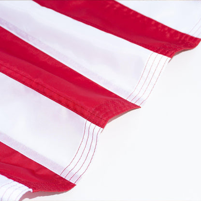 Close-up of a fabric with alternating red and white stripes, featuring visible stitching along the edge of each stripe. The material appears to be part of The FlagStars AMERICAN FLAG SET - COMPLETE BUNDLE, perfect for displaying on an adjustable aluminum flag pole with tangle-free spinners.