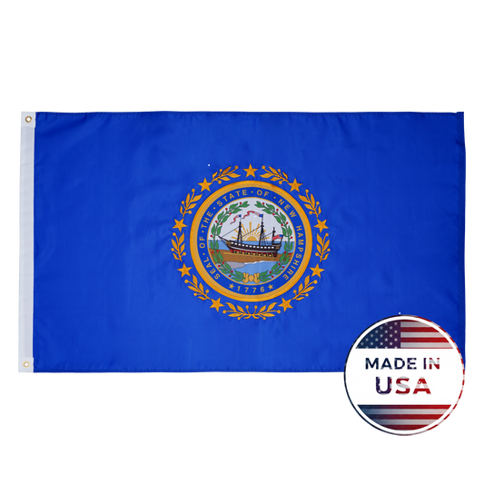 Flag Stars Inc’s New Hampshire State Flag – 100% Made in USA – features a blue background with the state seal, shown beside a round “Made in USA” American flag label. Built durable for outdoor use.