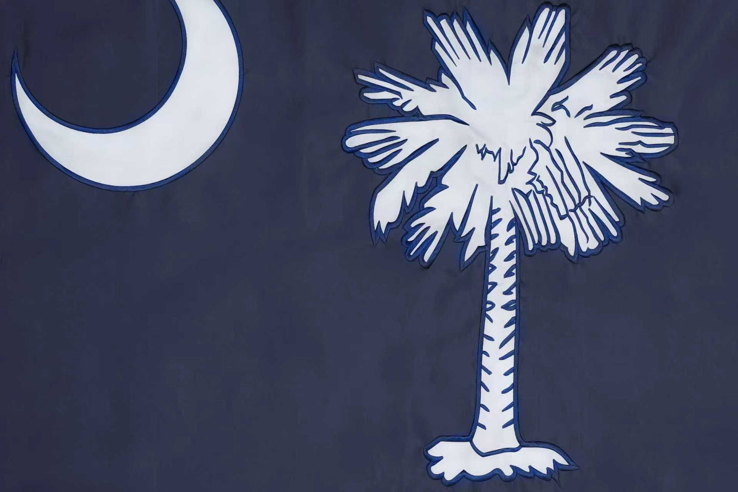 The South Carolina State Flag by Flag Stars Inc features a white palmetto and crescent on dark blue with raised embroidery for texture. 100% Made in USA.