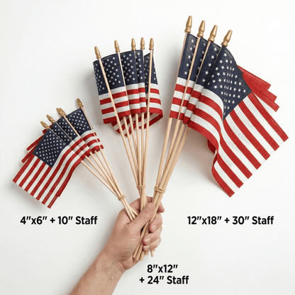 A hand holds Flag Stars Inc's Poly Cotton US Stick Flags (Made in USA) on natural wood sticks in 4"x6", 8"x12", and 12"x18" sizes—ideal parade flags for any celebration.