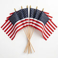 Seven Flag Stars Inc Poly Cotton US Stick Flags, each with a natural wood stick and made in the USA, are fanned out on a white background—ideal for parades or decorations.