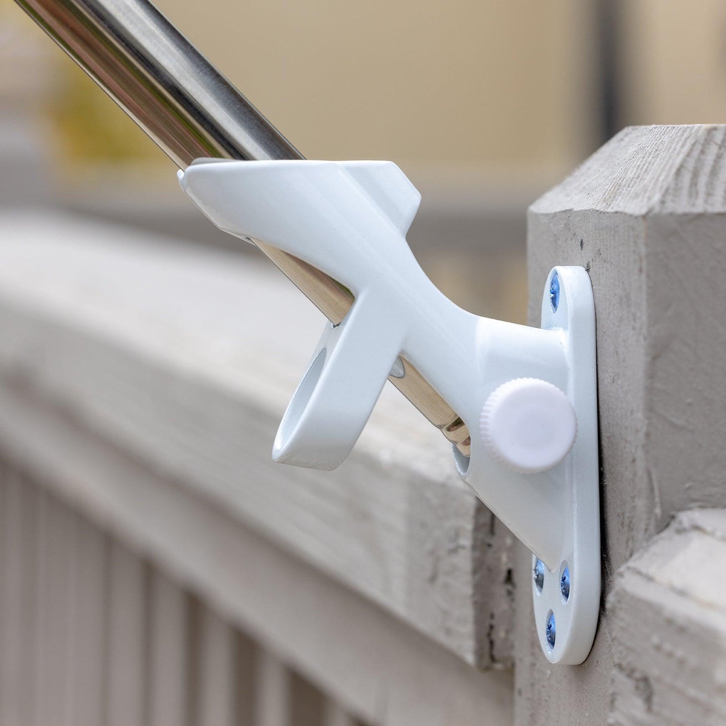 A FLAG MOUNTING BRACKET by The FlagStars, made in the USA, is mounted on a wooden surface with screws, holding a silver pole.